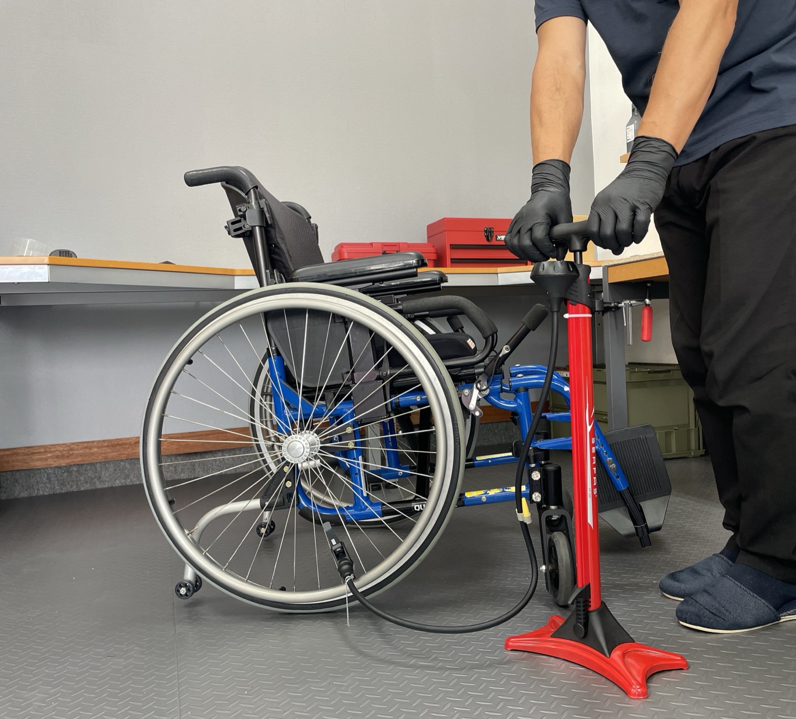 車いすのタイヤに空気を入れて点検する様子